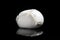 Italian buffalo mozzarella cheese from Campania region Italy on a black mirrored background with cutting light