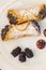 Italian cannoli on white plate with blackberries and chocolate c
