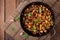 Italian Caponata with frying pan on a wooden background.