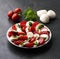 Italian caprese salad with tomatoes and mozzarella cheese with basil leaves