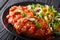 Italian Carne Alla Pizzaiola meat and fresh vegetable salad close-up on a plate. horizontal