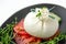 Italian cheese burrata, tomatoes and vegetables close-up. A layer of mozzarella with creamy straticella inside