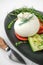 Italian cheese burrata, tomatoes and vegetables close-up. A layer of mozzarella with creamy straticella inside