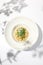 Italian cheese risotto on white plate. Creamy risotto topped parmesan cheese and espuma. Italian risotto with cheese on light