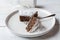 Italian chocolate, almond cake, torta caprese served sliced on a white plate with fork.