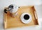 Italian coffee espresso maker moka pot and white cup of coffee on bamboo wooden tray