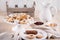 Italian Cookies with jam, almonds, milk bottles and pitcher on a beige colored tablecloth.