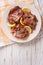 Italian cuisine: beef saltimbocca with lemon close up. Vertical