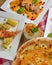 Italian cuisine concept flat lay, top view. Persimmon dishes menu, pizza, shrimps, salad, dessert.
