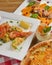 Italian cuisine concept flat lay, top view. Persimmon dishes menu, pizza, shrimps, salad, dessert