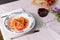 Italian dish, handmade spaghetti pasta, pici with tomato sauce on a table in the garden outdoors