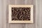 Italian dry brown twisted wholegrain pasta in wooden frame on beige wooden board as decorative picture background.