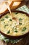 Italian egg soup stracciatella with farfalline pasta and parmesan close-up. vertical