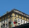 Italian flag against a vibrant Mediterranean colorful yellow building facade in Milan, Lombardy, Italy.