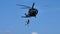 Italian flag flying hanging from the winch of a military helicopter in flight