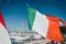 Italian flag over yacht parking in harbor