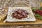 Italian flavors: sliced salami in a plate placed on a wooden table