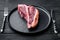 Italian Florentine T bone dry aged beef meat Steak, on plate, on black wooden table background