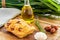 Italian focaccia with confit garlic cloves and rosemary, alongside tomatoes, garlic, olive oil and rosemary twig with foliage