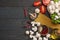 Italian food background, with tomatoes, parsley, spaghetti, mushrooms, oil, lemon, peppercorns on dark wooden table. Top view