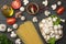 Italian food background, with tomatoes, parsley, spaghetti, mushrooms, oil, lemon, peppercorns on dark wooden table. Top view