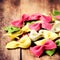 Italian Food - Fresh Italian Pasta on old wooden background close up. Raw Bow tie Colourful pasta macro.