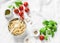 Italian food pasta background with copy space on white background, top view. Basil, whole grain spaghetti, cherry tomatoes, olive