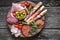 Italian food, prosciutto, grissini, smoked sausage, ham, olives, capers, sun-dried tomatoes on wooden background