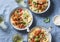 Italian food table. Pasta with slow cooker chicken with olives and sweet peppers, white wine. On a blue background