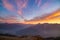 The Italian French Alps at sunset. Colorful sky over the majestic mountain peaks, dry barren terrain and green valleys. Sunburst a