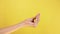 Italian gesture fingers together. isolated on yellow background female hand