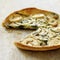 Italian goat cheese and spinach quiche with slice missing. Conceptual image