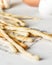 Italian grissini breadsticks on baking paper with letters. Light photo on a green background.