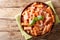 Italian homemade Tortiglioni pasta with parmesan basil in tomato sauce close-up in a plate. Horizontal top view