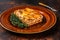 Italian Lasagne with tomato bolognese sauce and mince beef meat on a rustic plate. Dark background. Top view