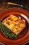 Italian Lasagne with tomato bolognese sauce and mince beef meat on a rustic plate. Dark background. Top view