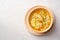 Italian lemon chicken orzo soup in bowl on concrete background