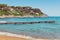 Italian maritime coast of the Island of Elba with rocky cliff ridge, perched house and boardwalk. Sea, trees and rocks in Italy in