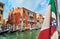 Italian maritime flag and Venetian Renaissance waterfront palaces, gondola stations, Venice, Italy. Travel destinations