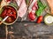 Italian meat plate with bread and antipasti on rustic wooden background, top view