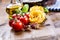 Italian and Mediterranean food ingredients on wooden background.Cherry tomatoes pasta, basil leaves and carafe with olive oil.