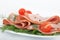 Italian mortadella on white plate with tomato