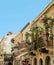 Italian narrow street between houses, stairs leading up and restaurants with tables outside