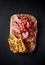 Italian Parma Ham, Coppa and Salami with bread toasts on wooden chopping boardpasto. Top view