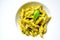 Italian pasta with basil pesto on a white plate