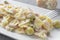 An italian pasta dish farfalle type topped with tuna capers and olives