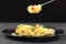 Italian pasta fork. Plate with spaghetti on black background