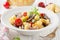 Italian pasta with fried vegetables and mushrooms, zucchini, cherry tomatoes, champignon, cheese and Basil. White plate