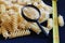 Italian pasta - spirals made of durum wheat, magnifying glass and centimeter. The concept of examination, selection of the best