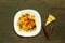 Italian pasta with tomato sauce and meatballs in a white plate on a wooden background. Concept of popular american spaghetti.